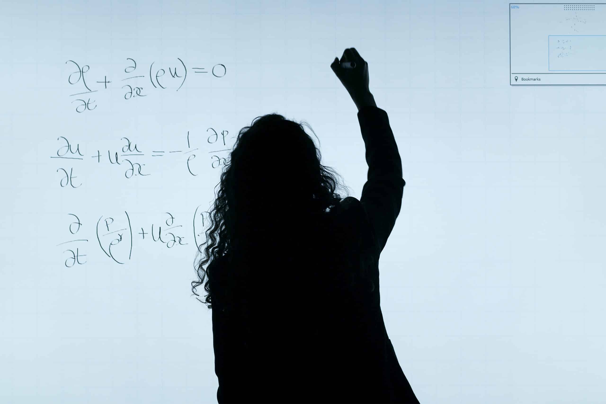 a imagem, utilizada para representar a importância da matemática para a programação, retrata uma mulher resolvendo cálculos matemáticos