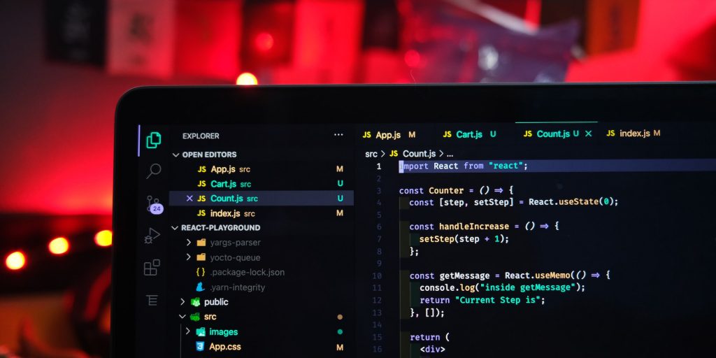 A imagem mostra um computador aberto em uma tela de código que utiliza diversas tecnologias JavaScript, como o Nuxt.js