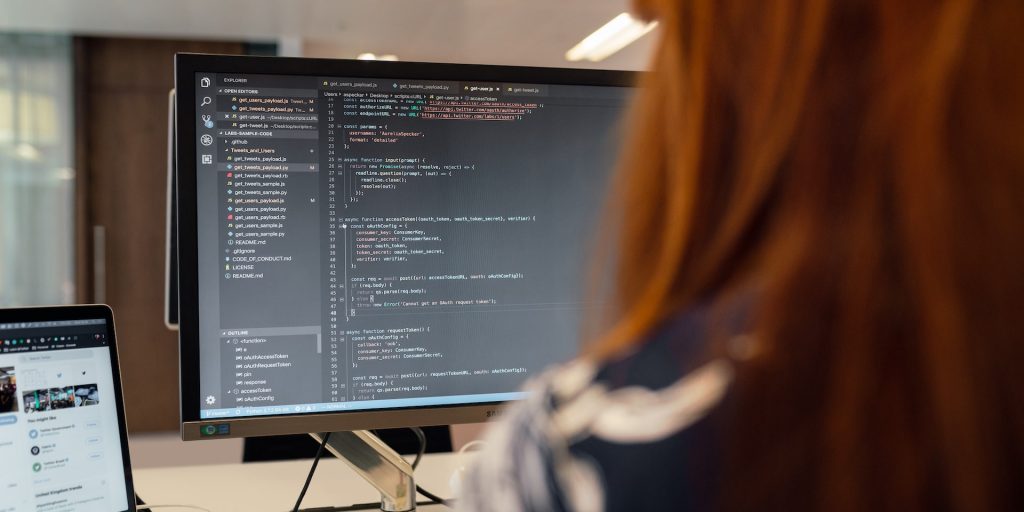A imagem mostra uma profissional trabalhando como desenvolvedora full stack à frente de um computador